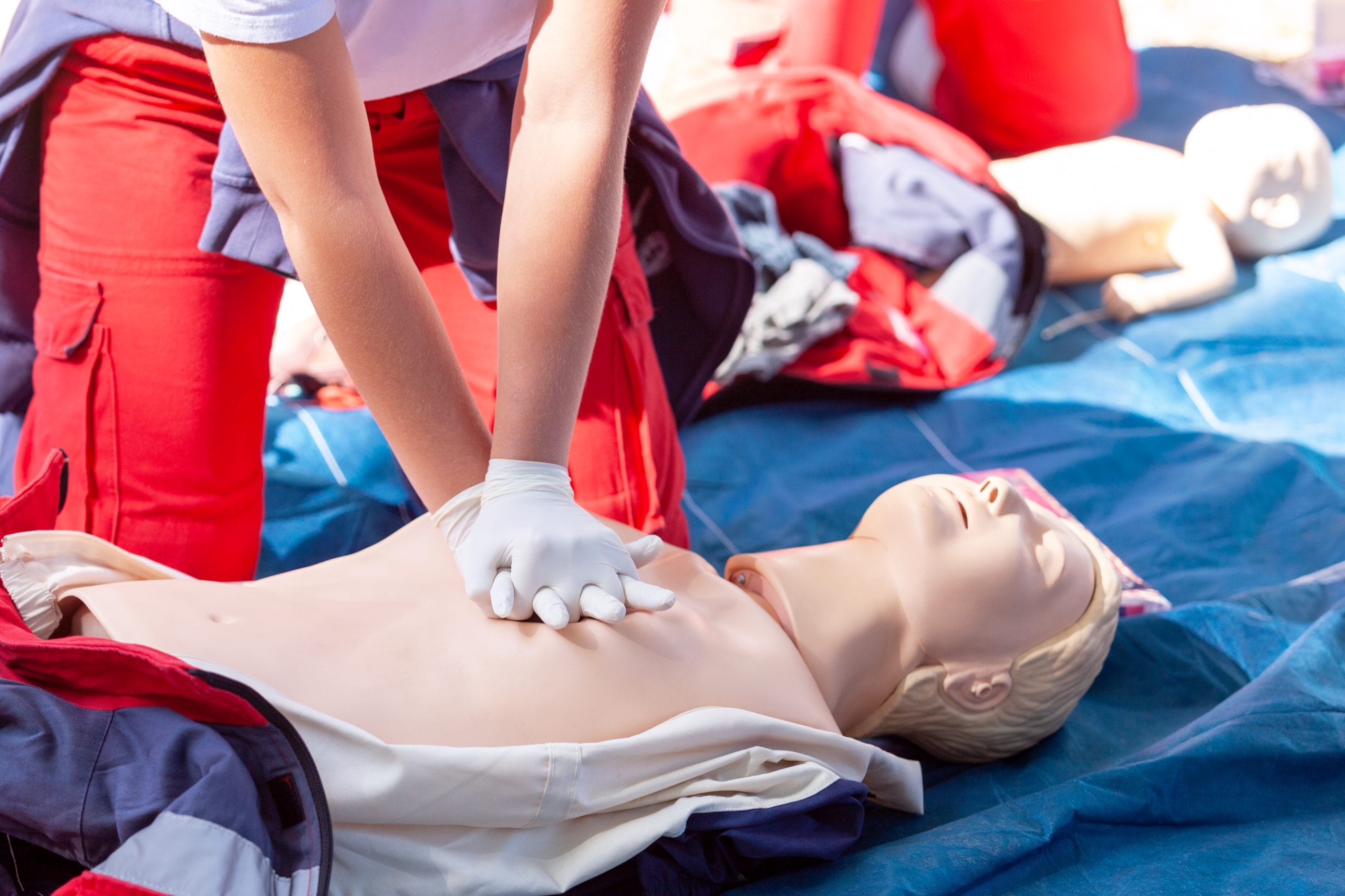 Emergency first aid at work course - person carrying out CPR training on a dummy